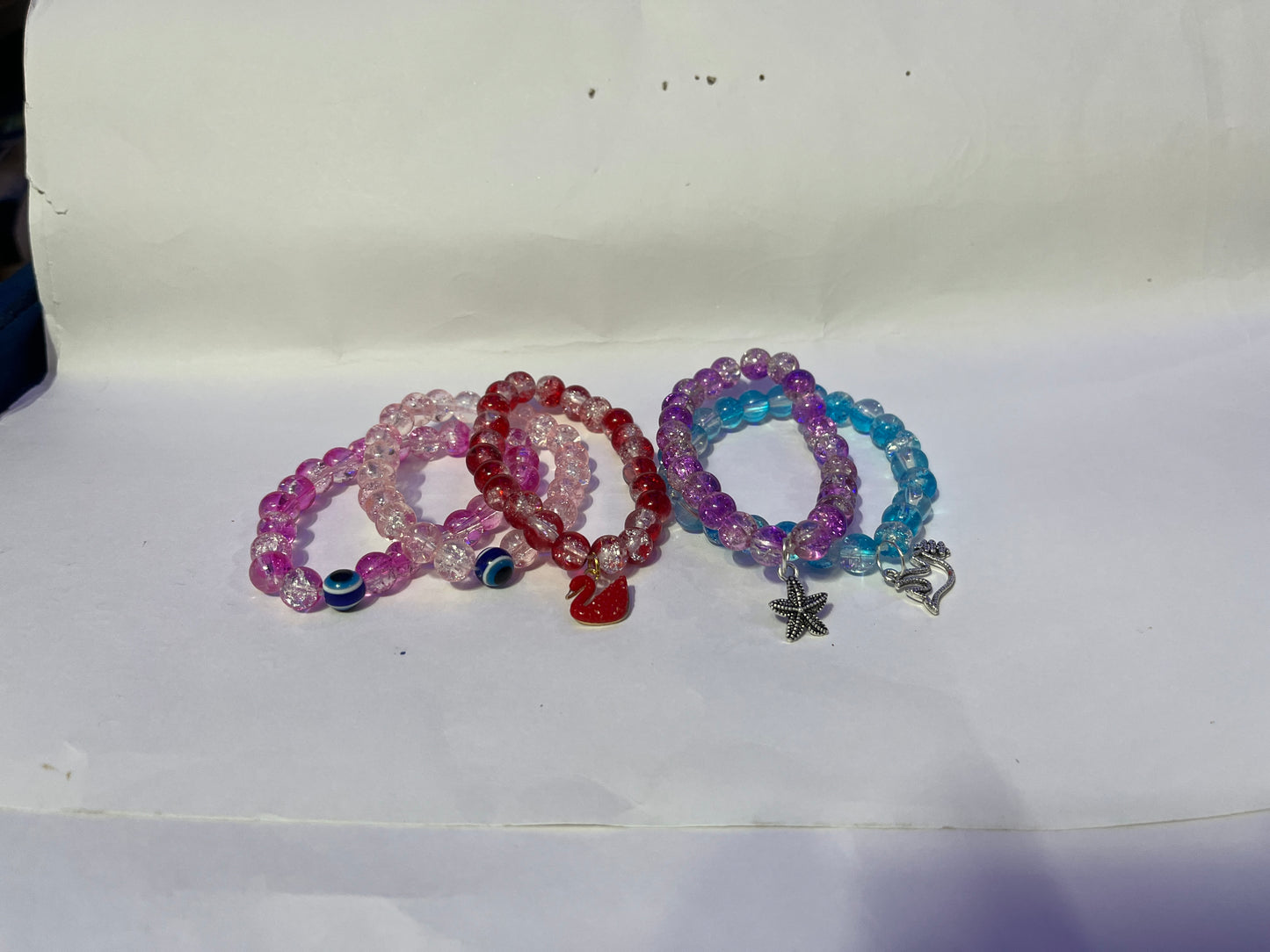 bracelets Multiple beaded, each with distinct colors and charms.